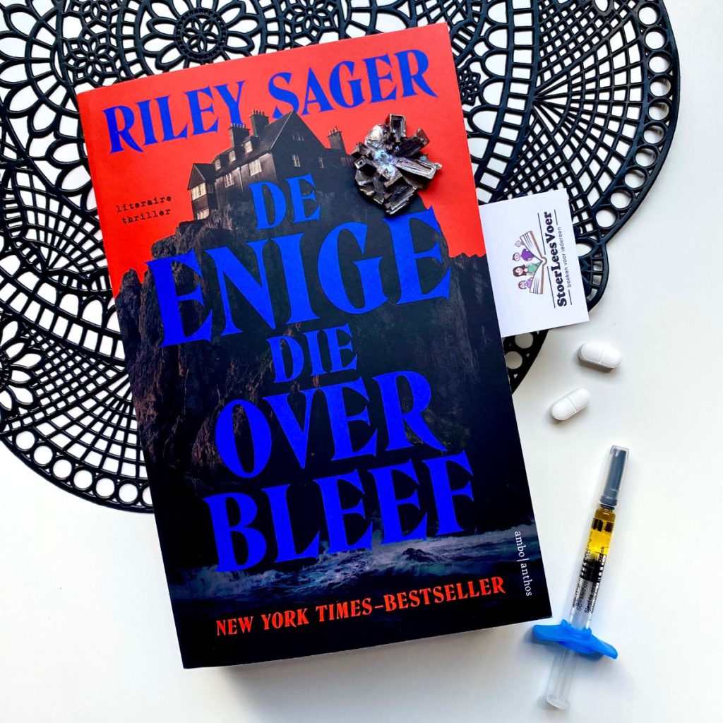 De enige die overbleef riley sager boek voorkant cover omslag huis op klif blauw rood zwart kleuren uitgeverij ambo anthos literaire thriller